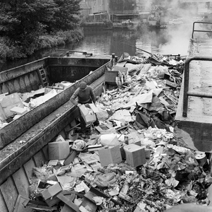 125892 Afbeelding van het storten van huisvuil in vuilnisschuiten in de Biltsche Grift op het Vaaltterrein te Utrecht.
